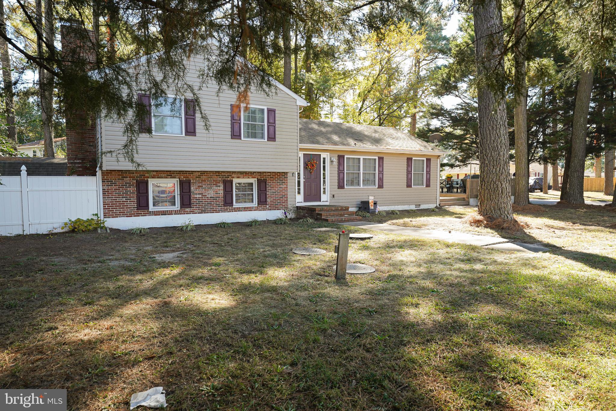 a front view of a house with a yard and large tree