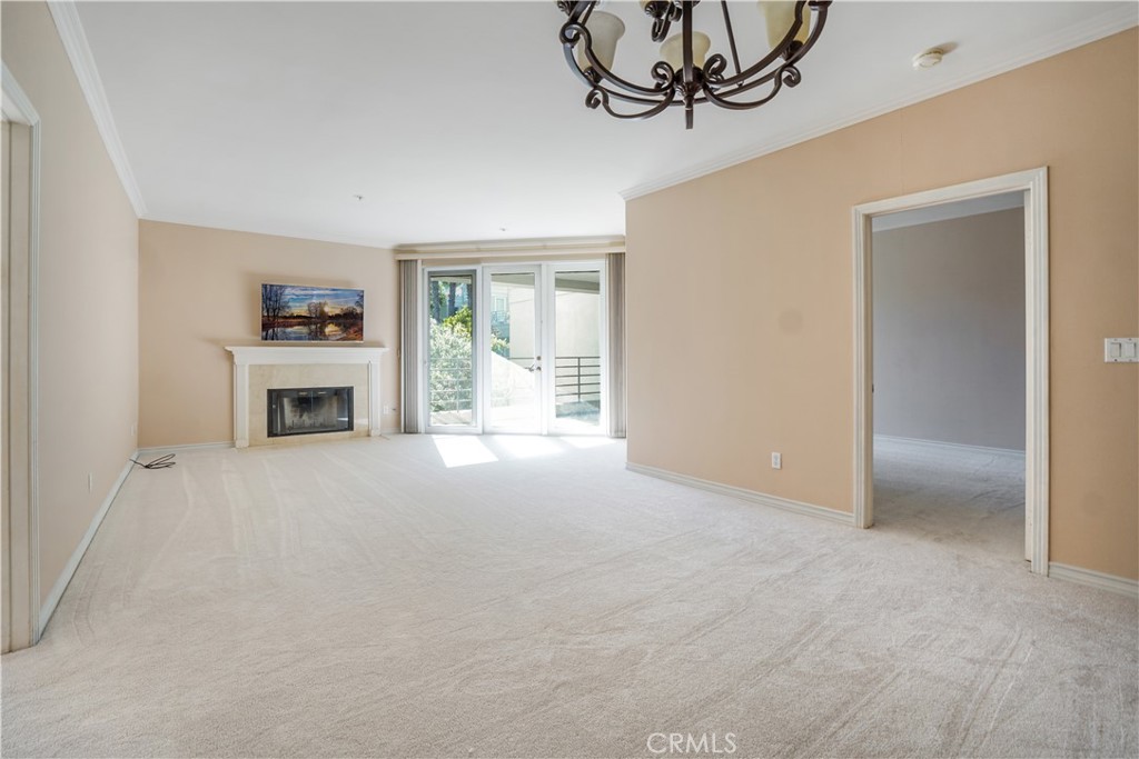 a view of a livingroom with a fireplace a ceiling fan and windows