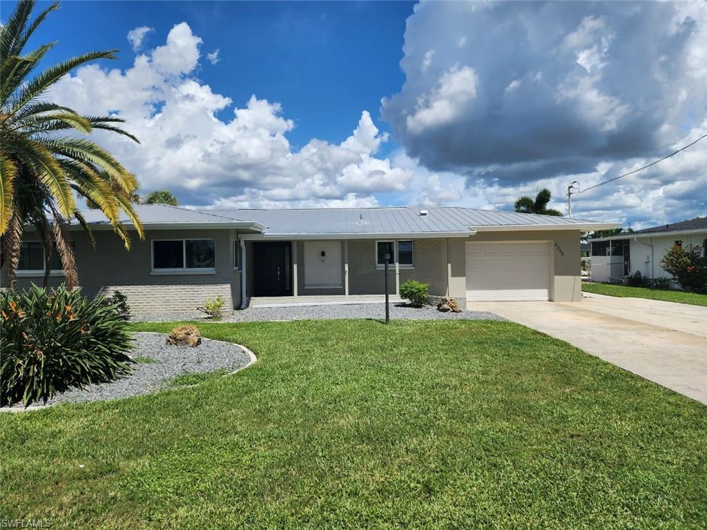 Single story home featuring a garage and a front yard