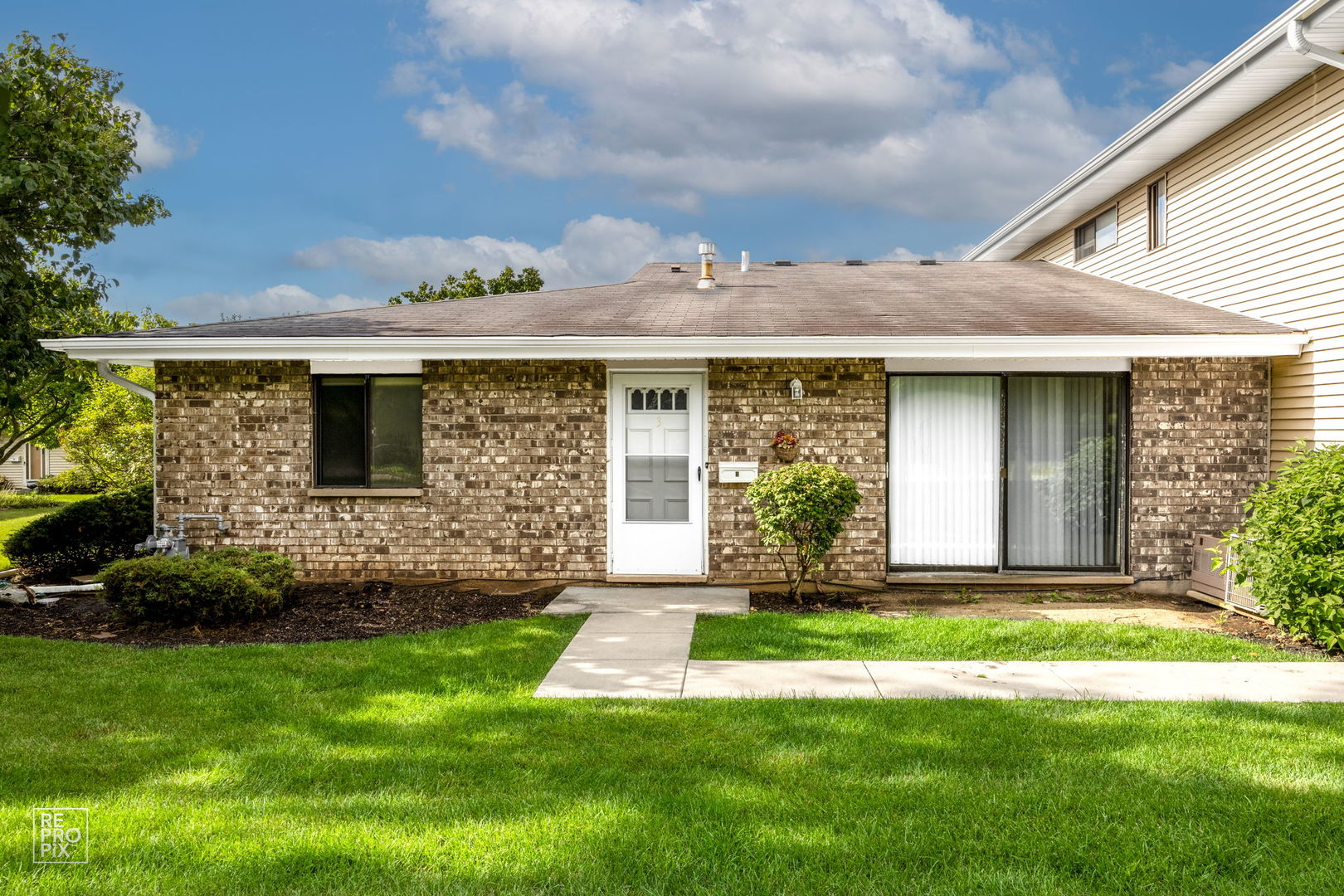 a front view of a house with a garden and yard