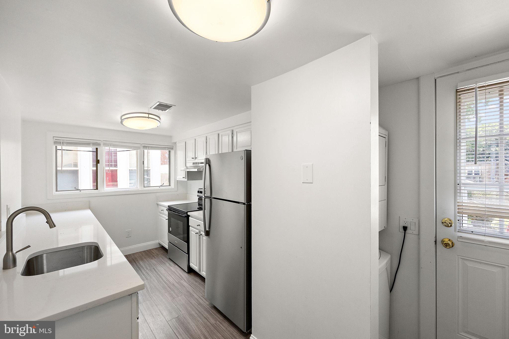 a kitchen with a refrigerator a sink and cabinets