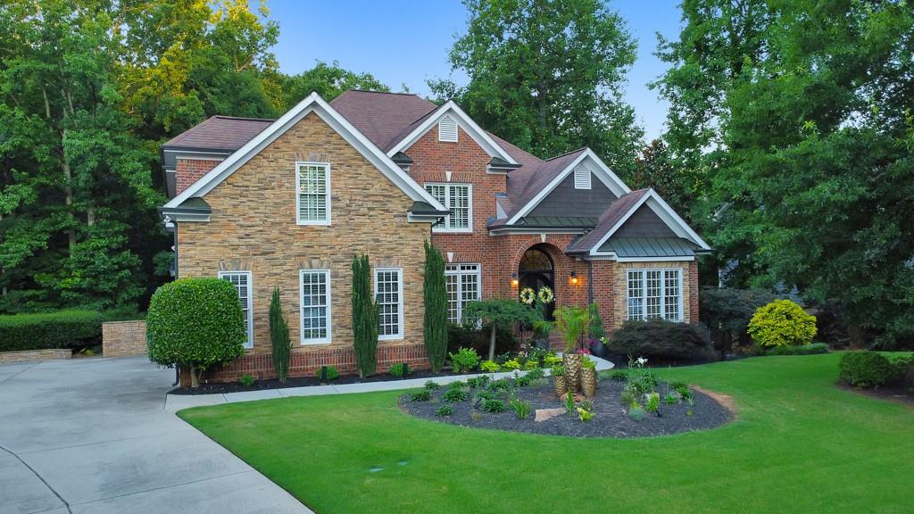 a front view of a house with a garden and plants