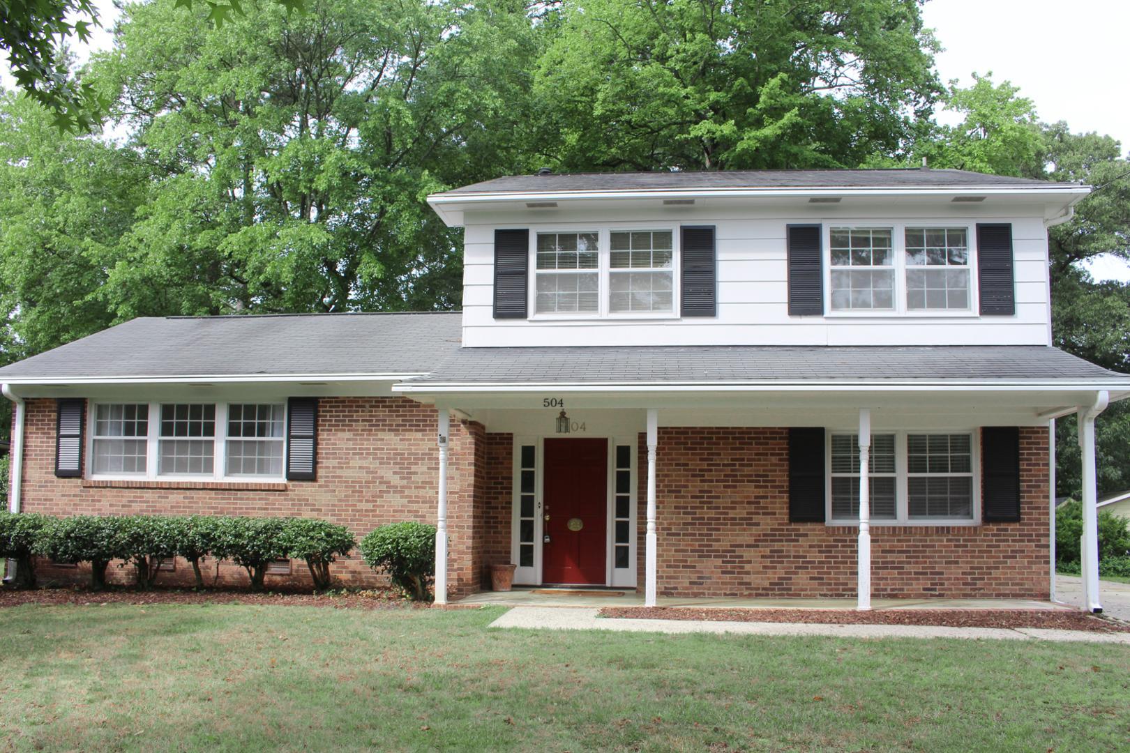 front view of a brick house with a yard