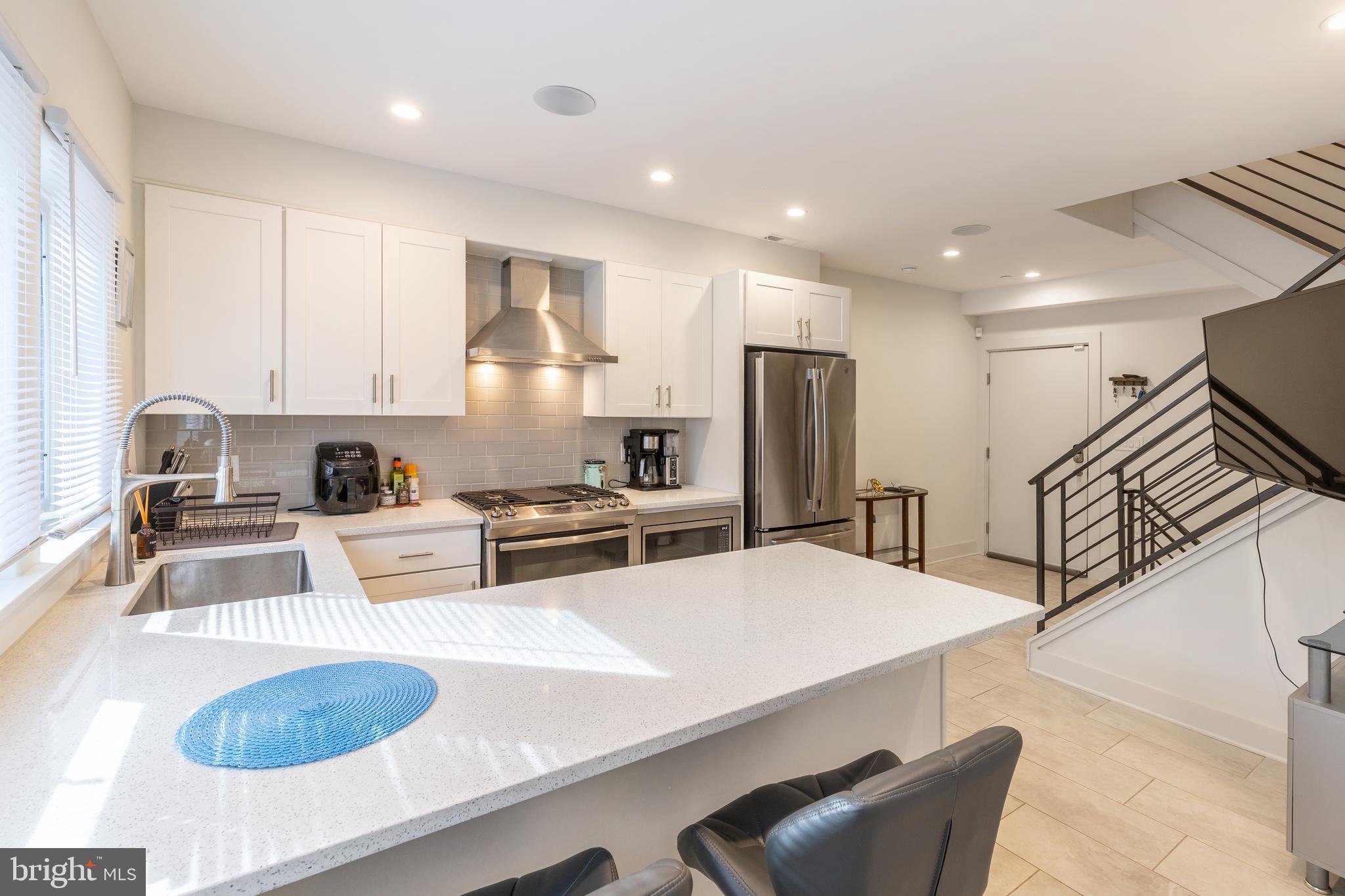 a kitchen with stainless steel appliances granite countertop a sink refrigerator and cabinets