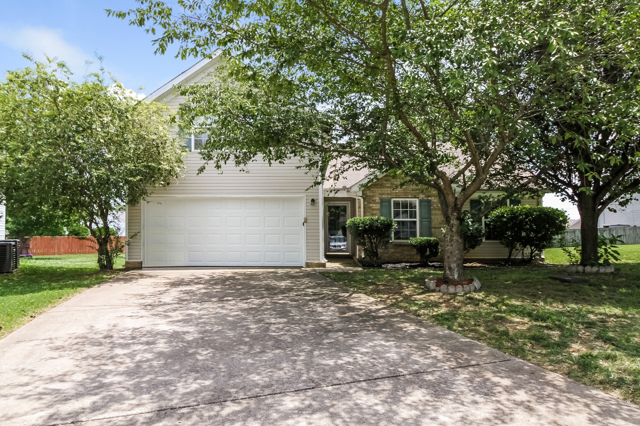 a view of a house with a yard and large tree