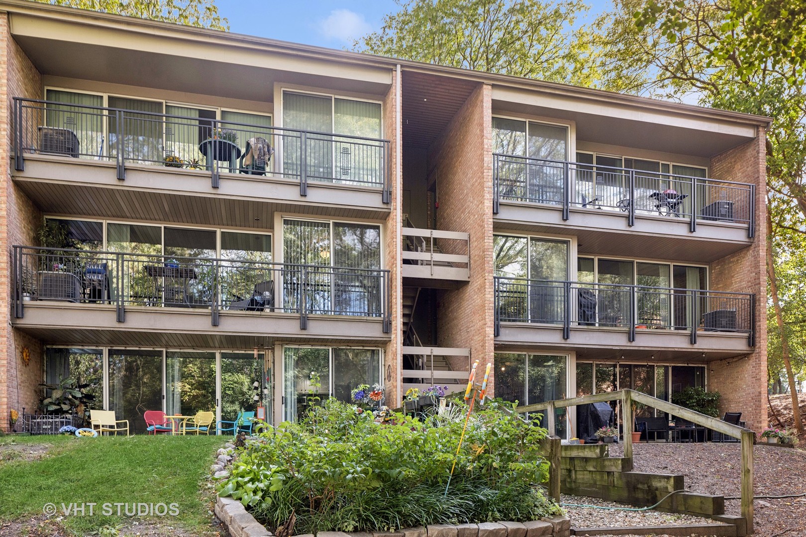 a front view of a building with a garden and plants