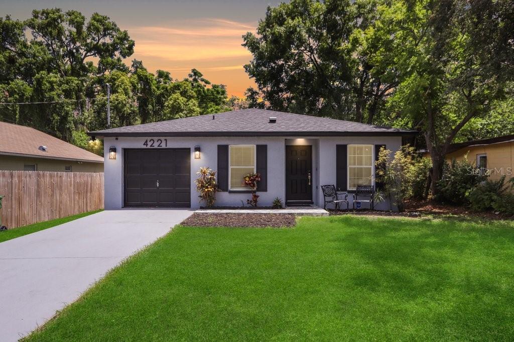 a front view of a house with patio and garden