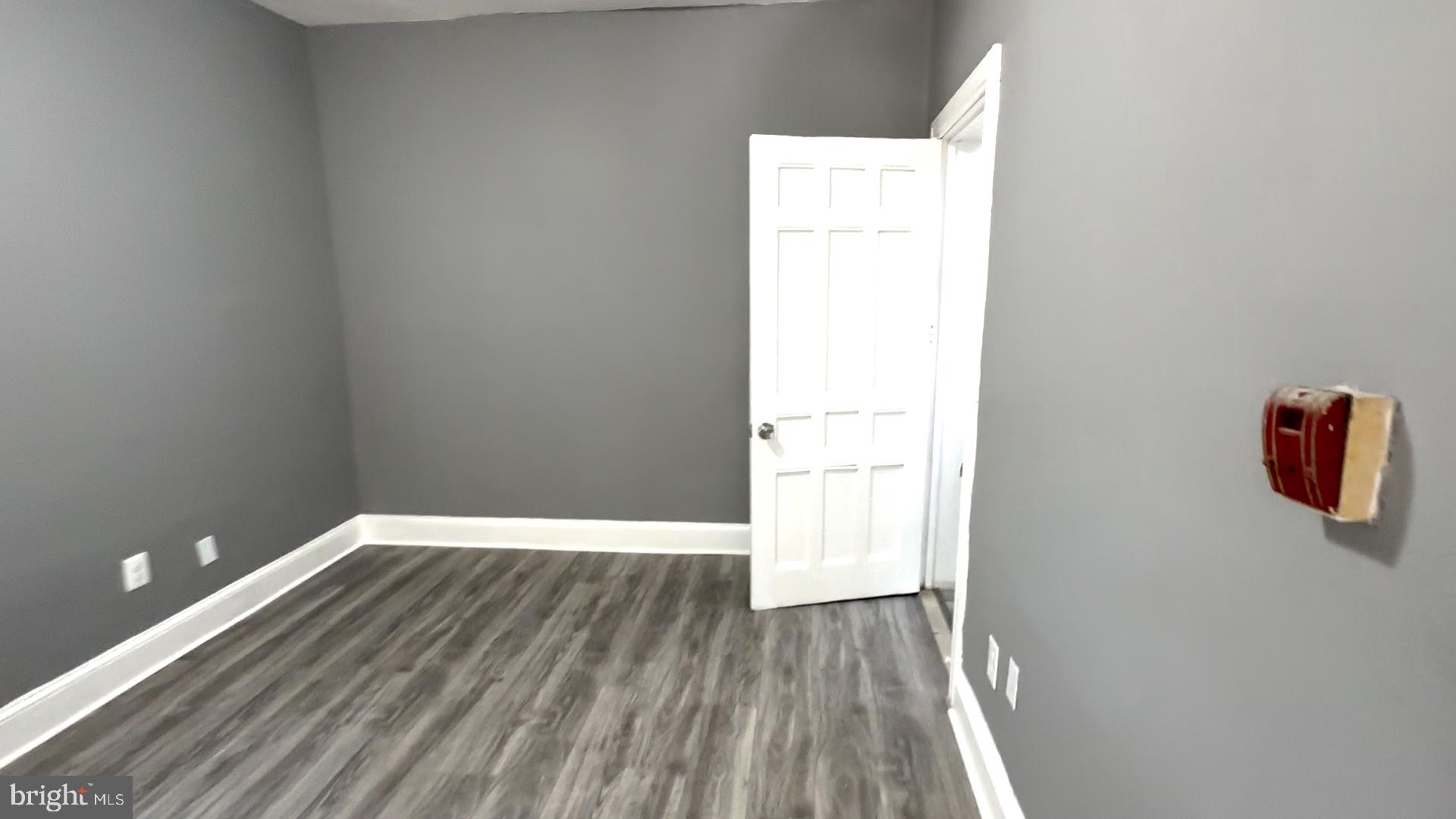 a view of a room with wooden floor and white walls