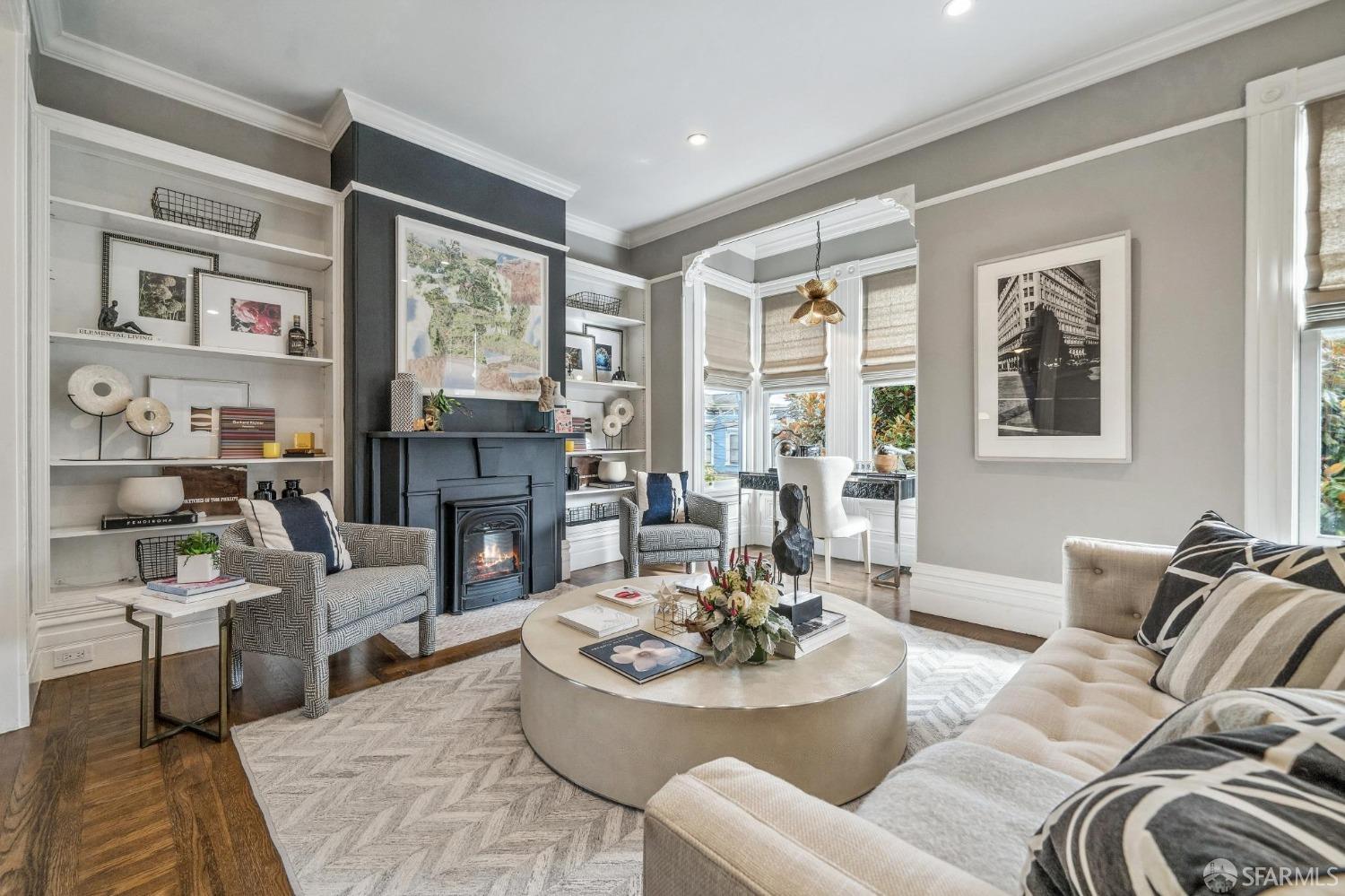 a living room with fireplace furniture and a large window