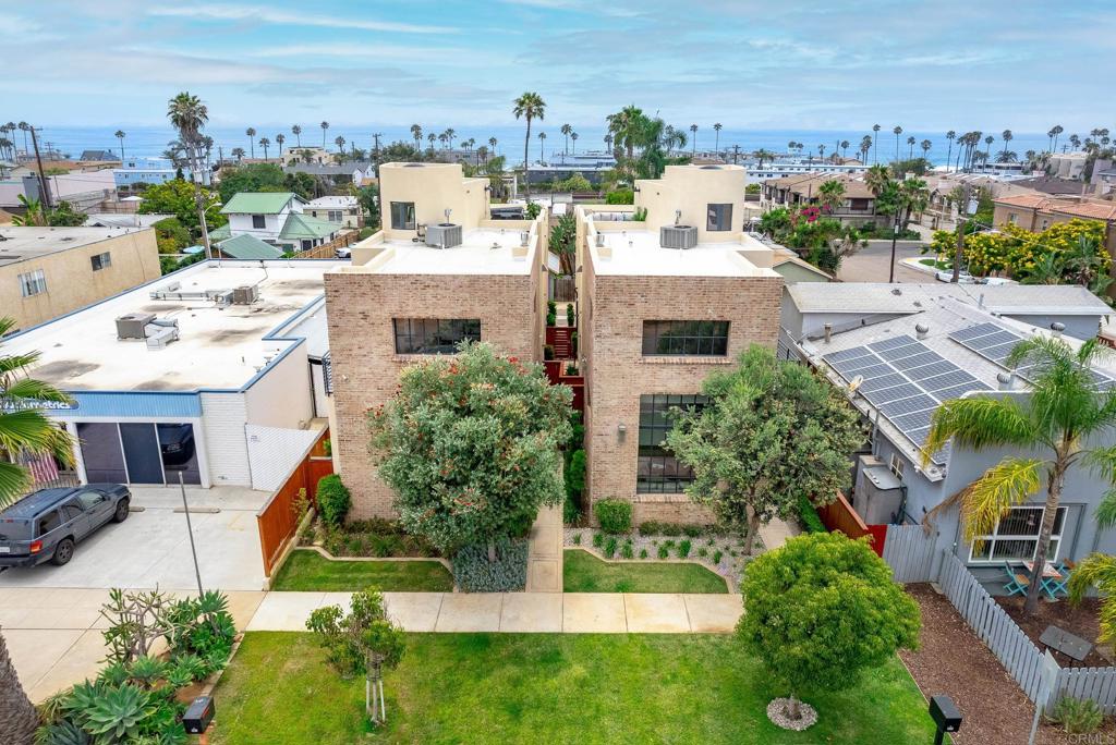 an aerial view of residential houses with outdoor space and trees