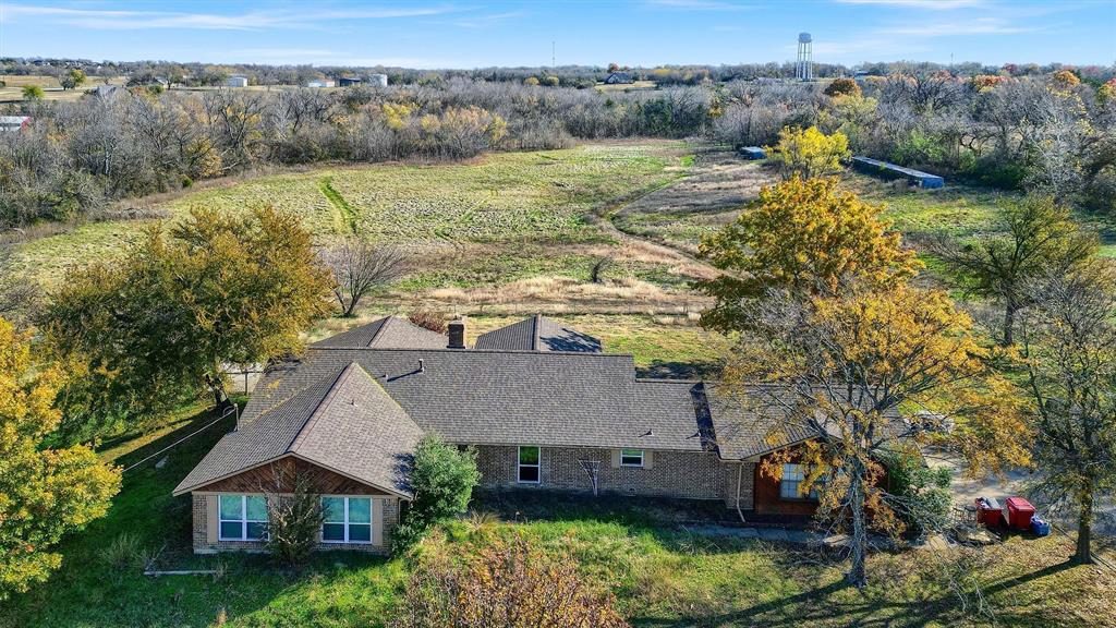 an aerial view of a house with a yard and lake view