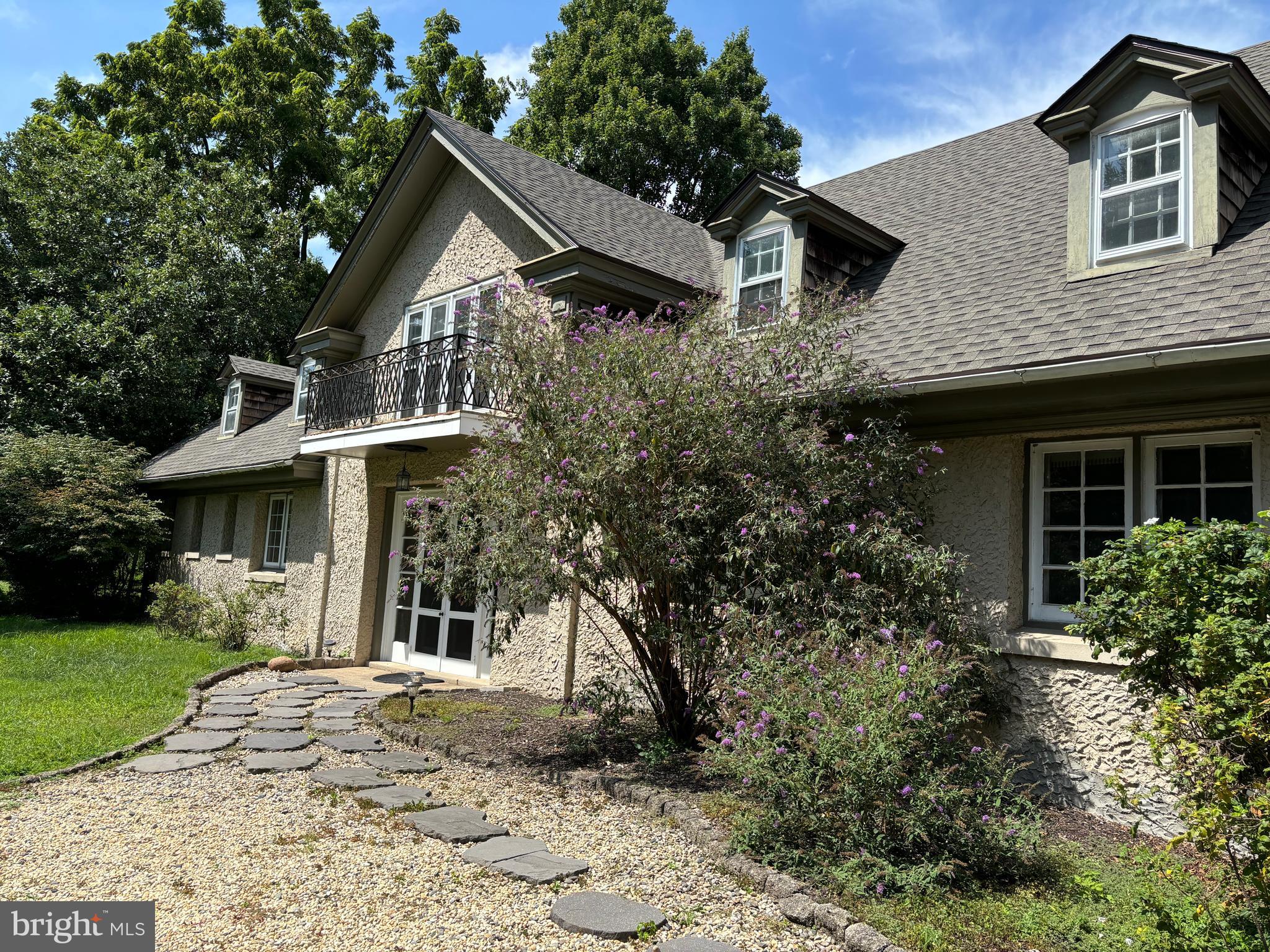 a front view of a house with a yard and potted plants