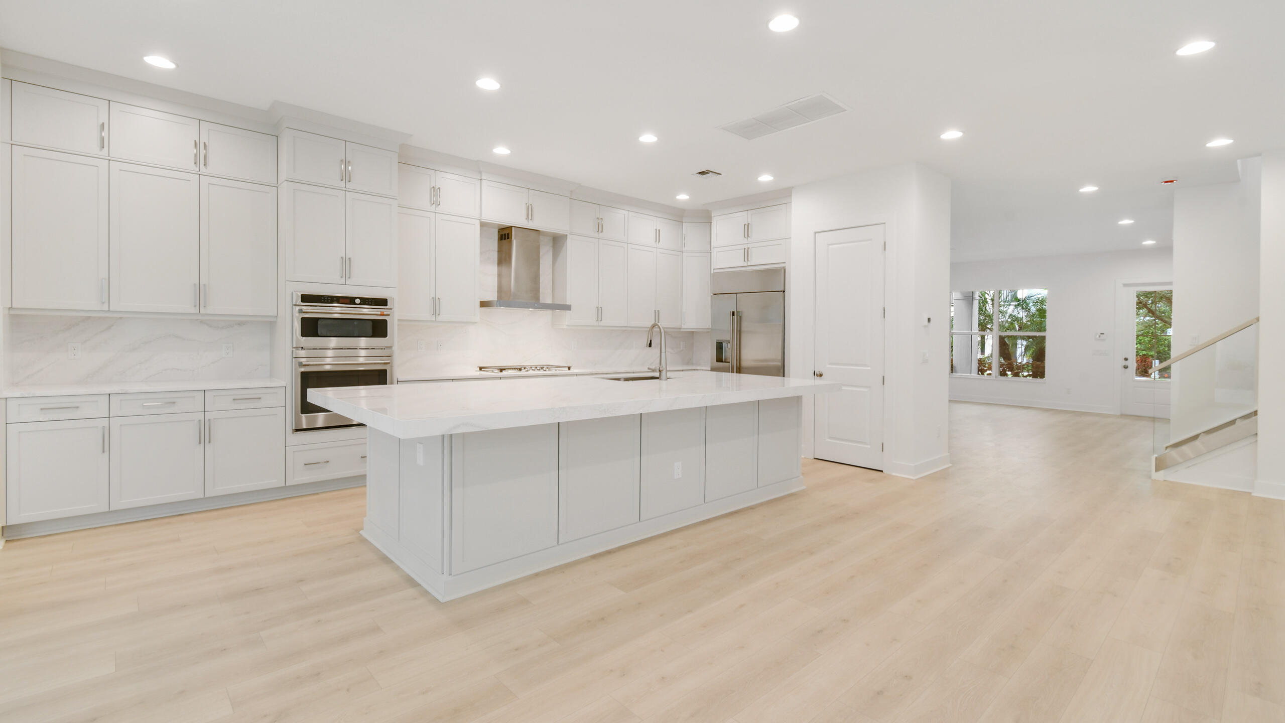 a kitchen with kitchen island sink stove and white cabinets