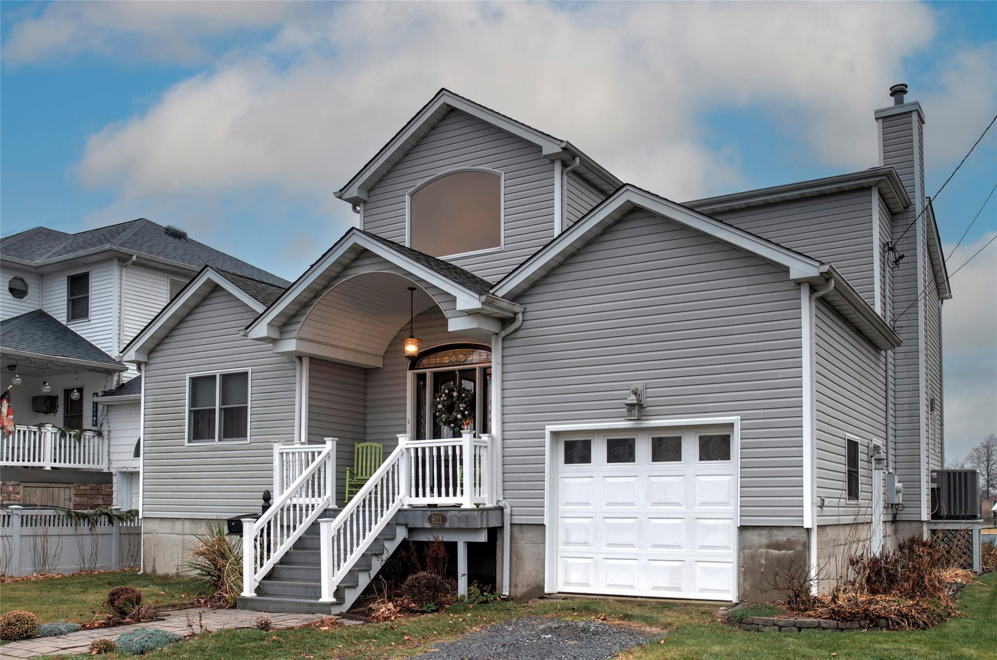 View of front of home featuring a garage and central air condition unit