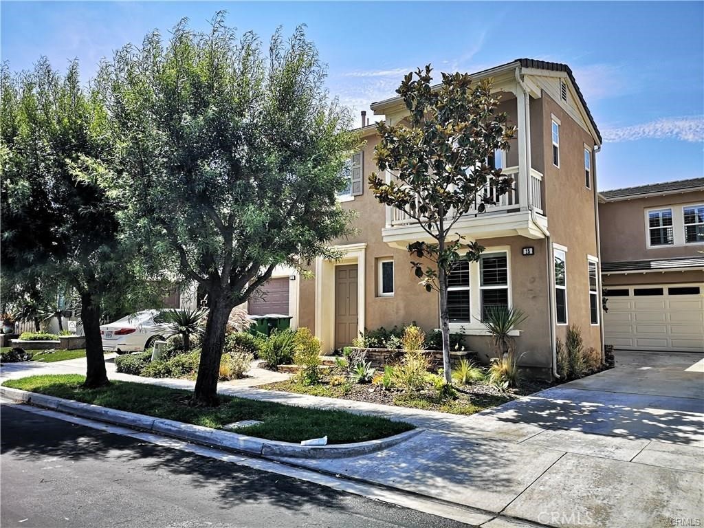 a front view of a house with a yard and tree s