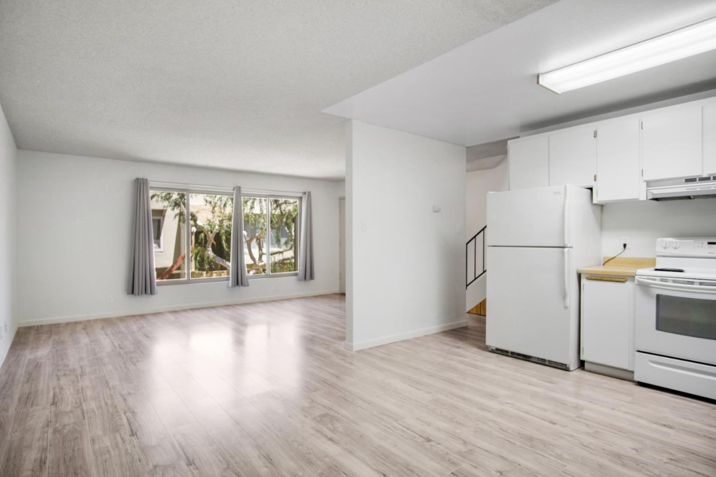 a view of a kitchen with wooden floor and electronic appliances