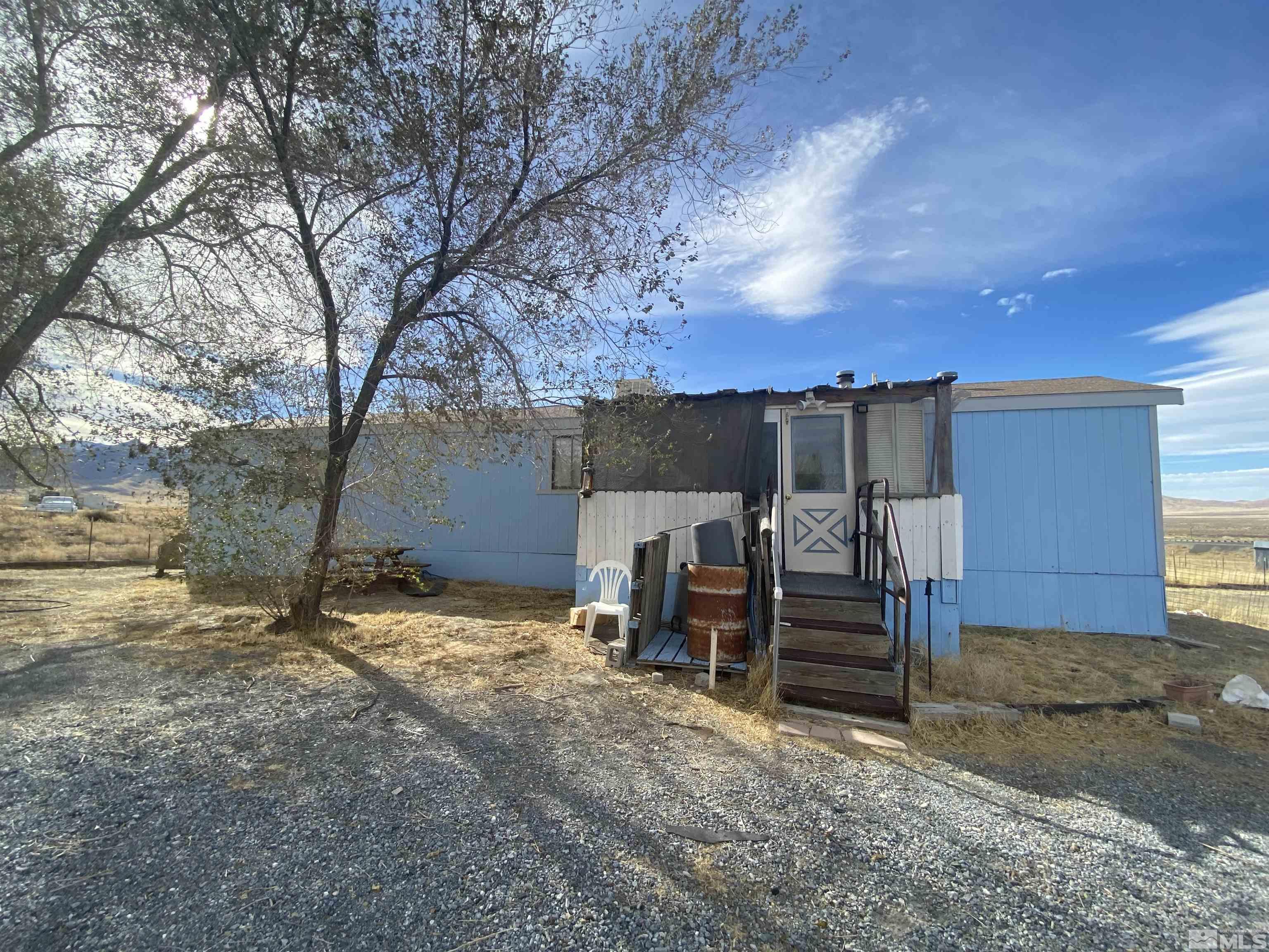 a view of a house with backyard and a tree