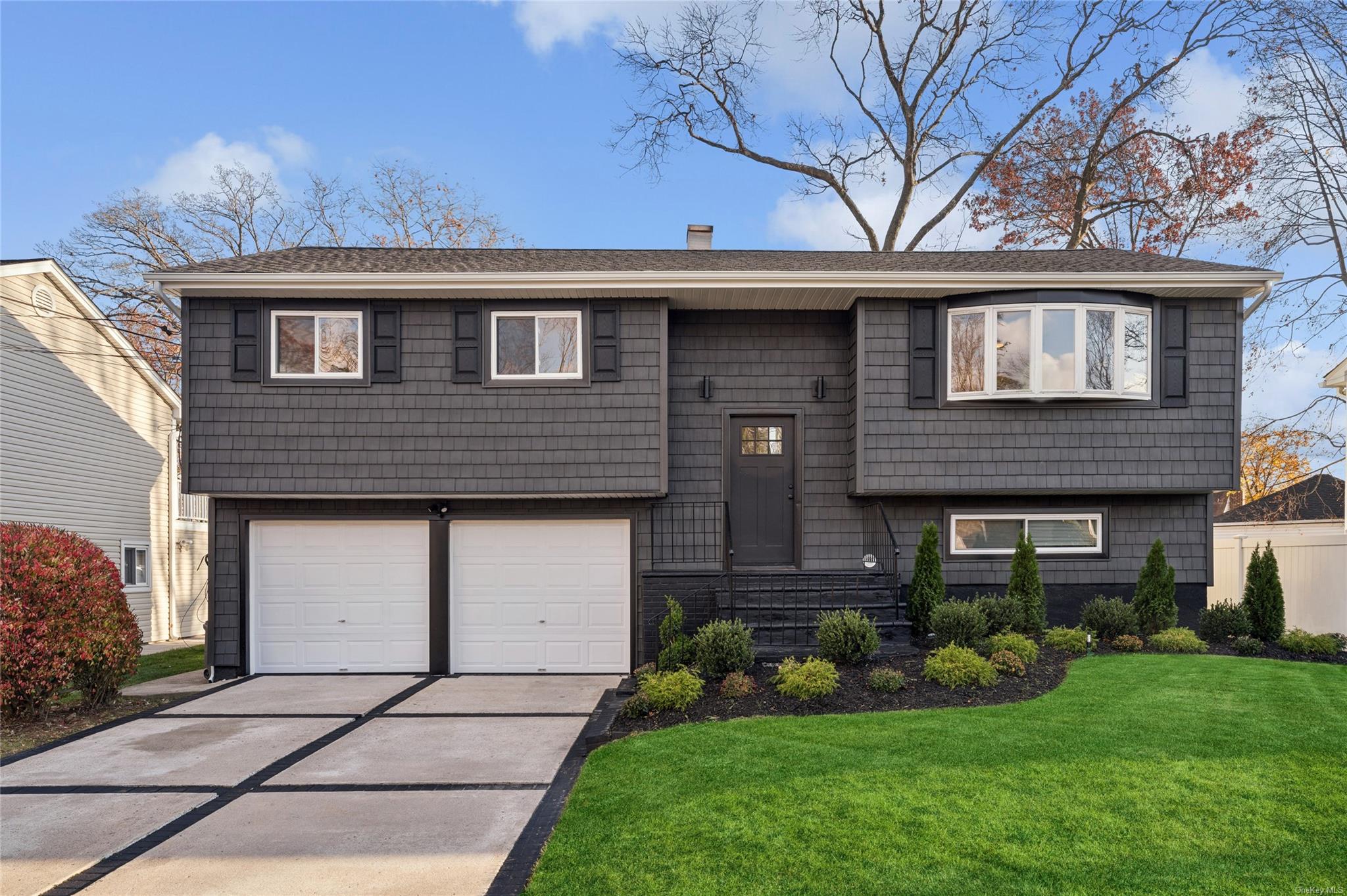 Split foyer home featuring a garage and a front yard