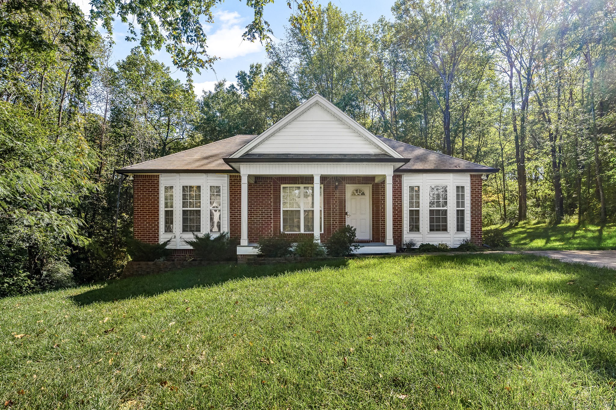 a view of a house with a yard and porch