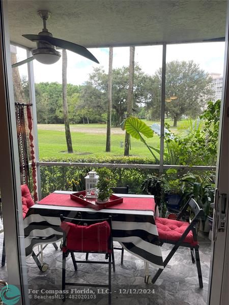 a view of a patio with a table chairs and a floor to ceiling window