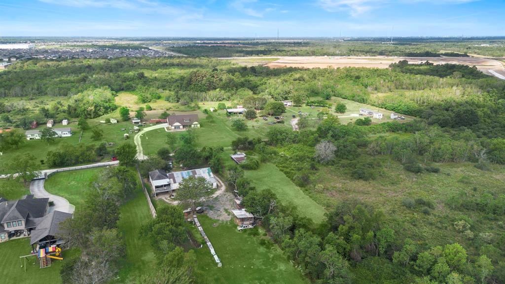 an aerial view of residential houses with outdoor space and trees