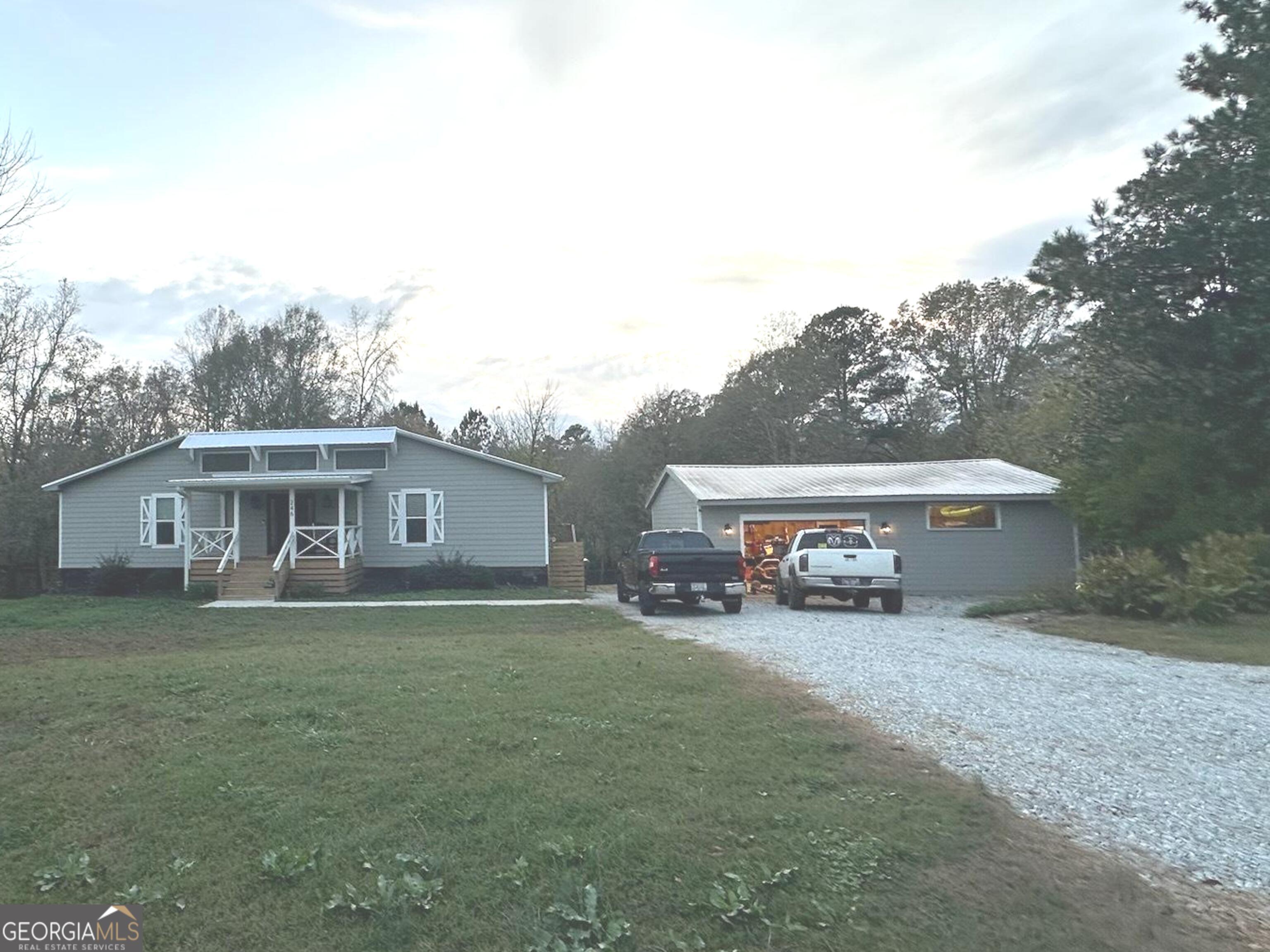 a view of a house with a yard and large trees