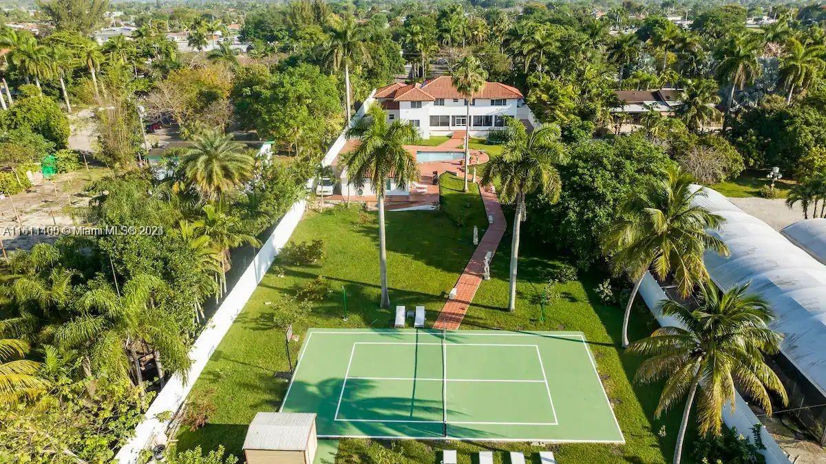 a view of a tennis ground with large trees