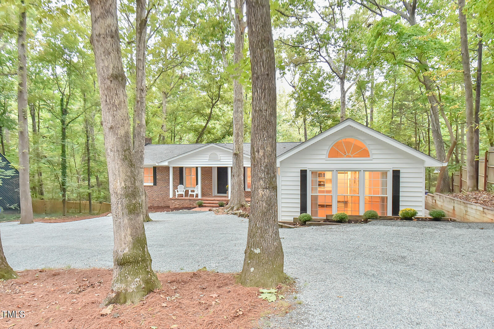 a front view of a house with a yard and large tree