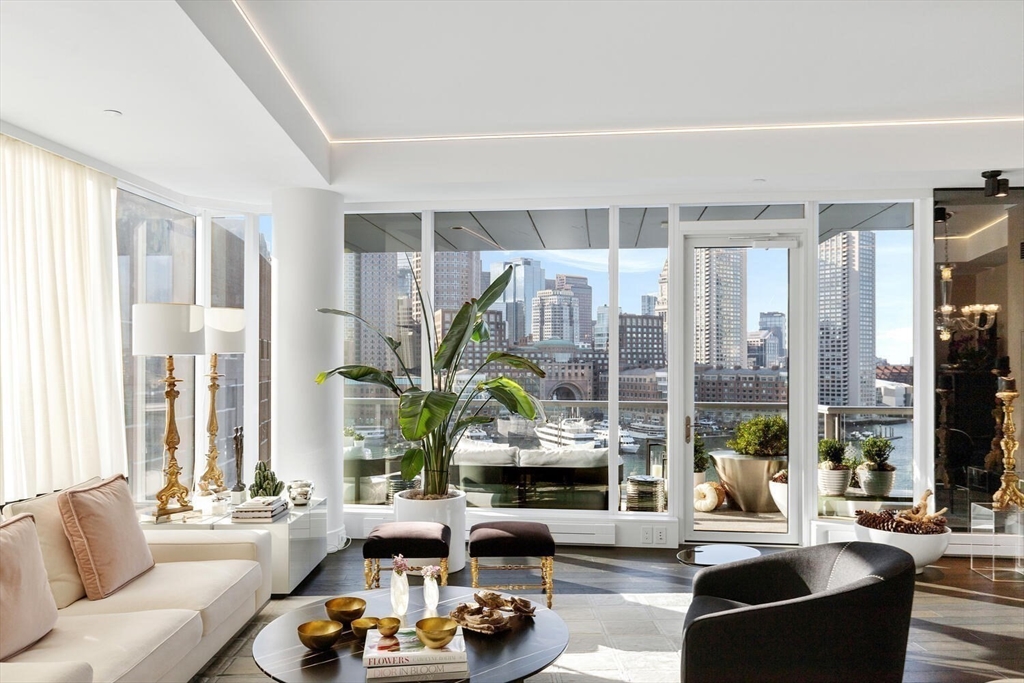 a living room with furniture a large window and a chandelier