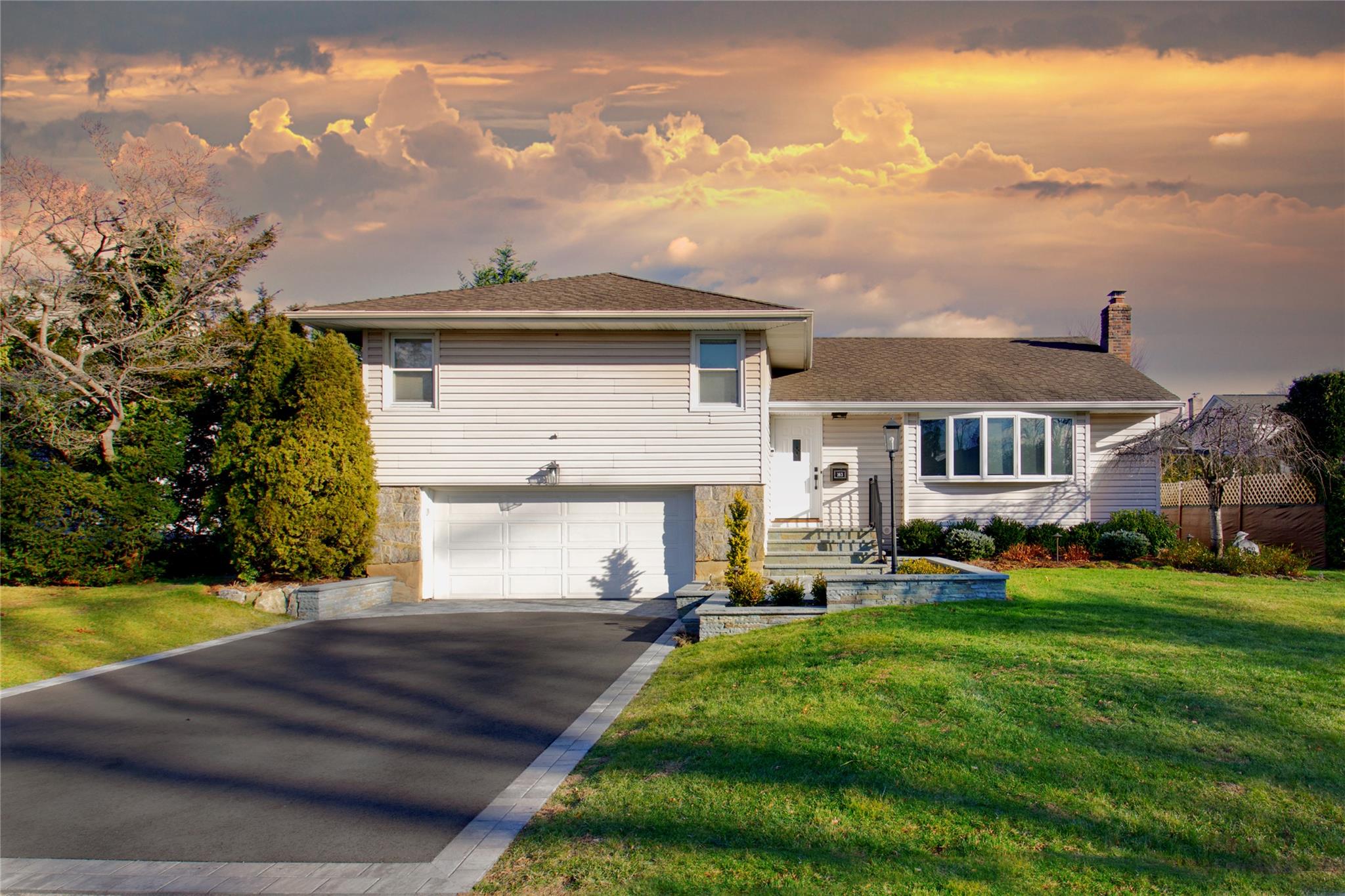 Tri-level home with a lawn and a garage