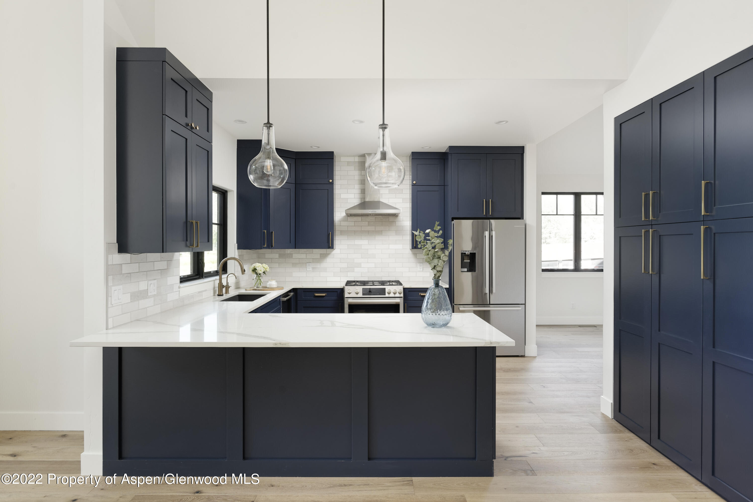 a kitchen with stainless steel appliances kitchen island granite countertop a refrigerator and a sink