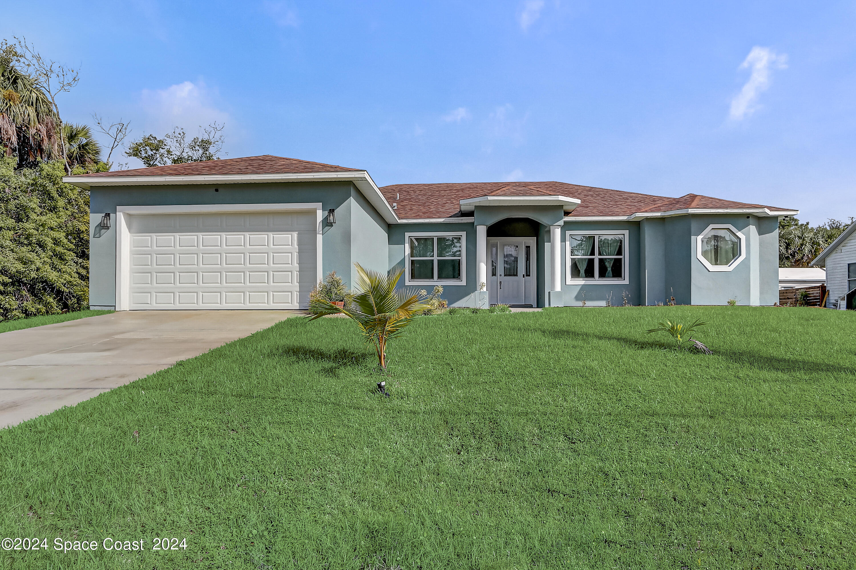 a front view of a house with a garden and yard