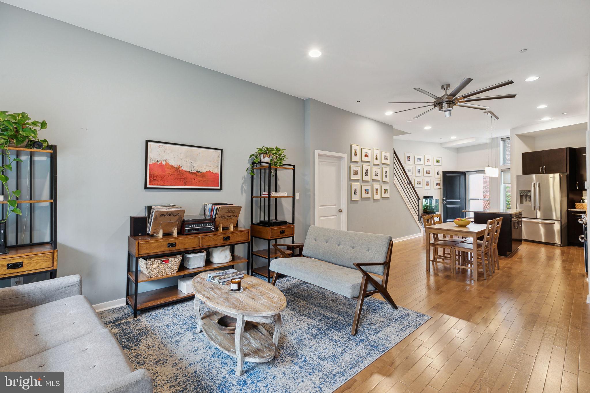 a living room with furniture a table and kitchen view