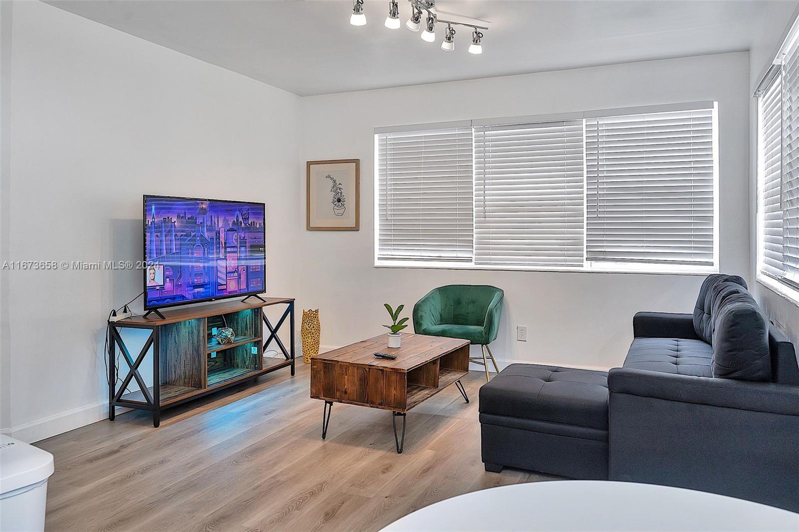 a living room with furniture a window and a flat screen tv