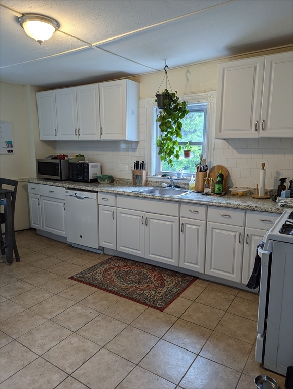 a kitchen with a sink window and cabinets