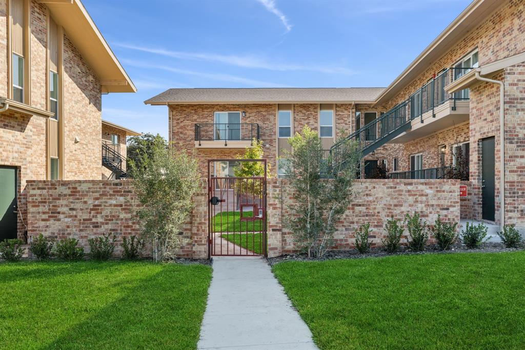 a view of a brick house with a yard