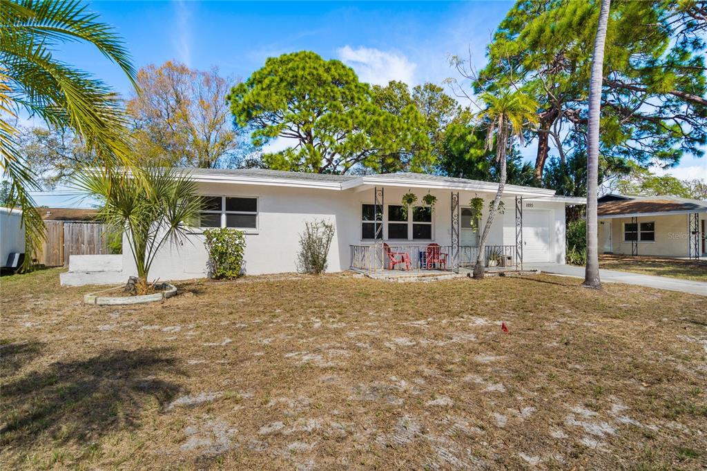 a view of a house with backyard and tree