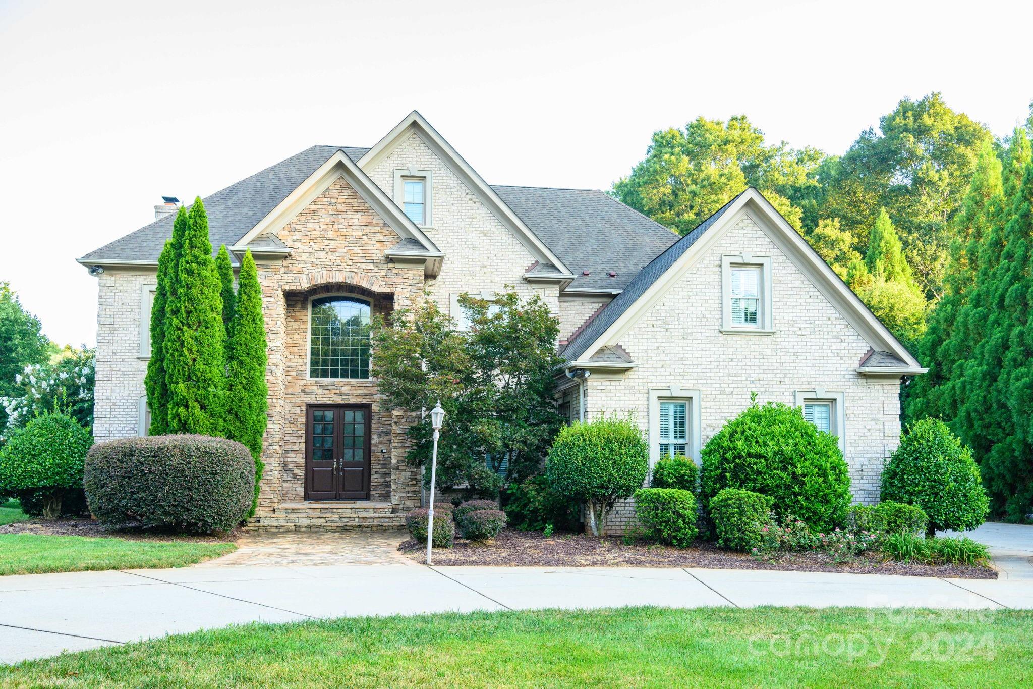 a view of a house with a yard and potted plants