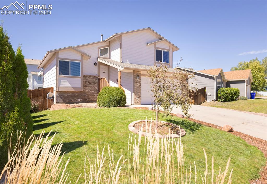 Front facade with a garage and a front lawn