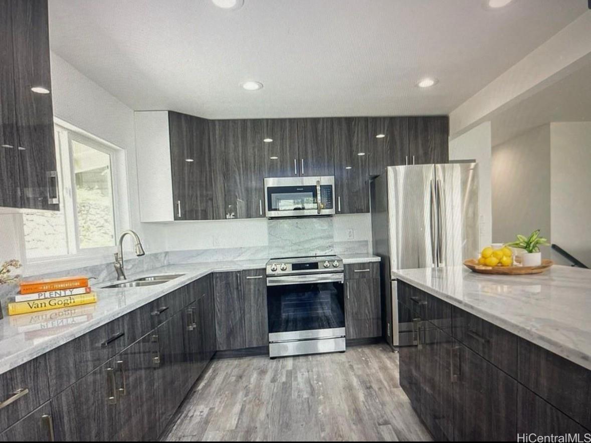 a kitchen with stainless steel appliances a sink stove and refrigerator