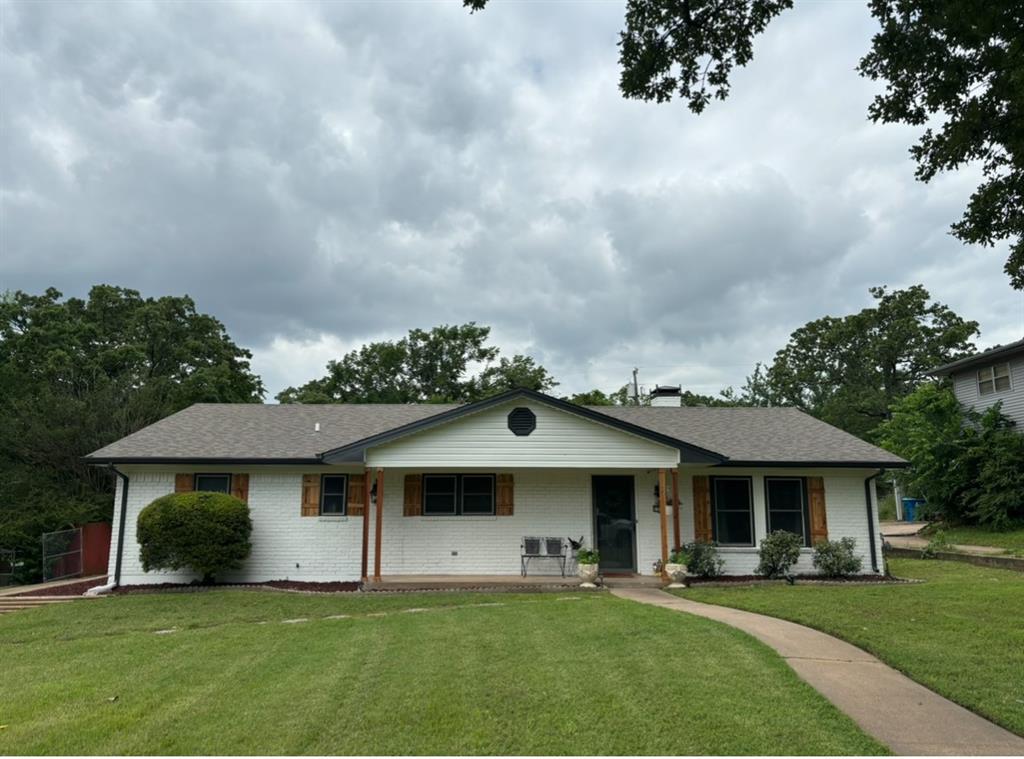 a front view of a house with a garden and trees