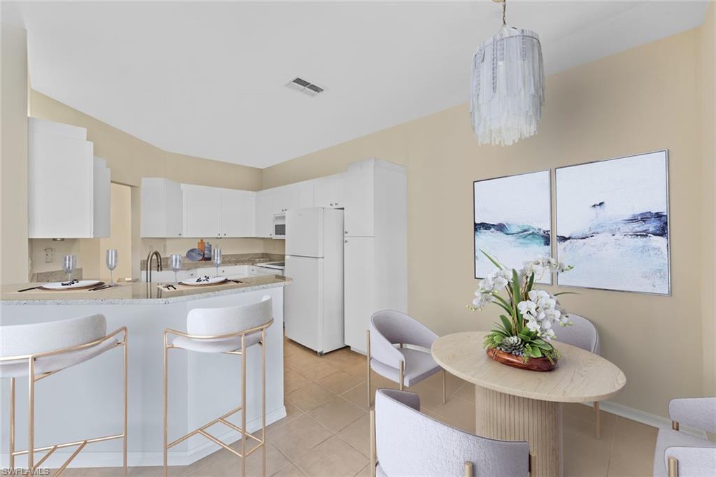 a kitchen with stainless steel appliances kitchen island granite countertop a table and chairs in it