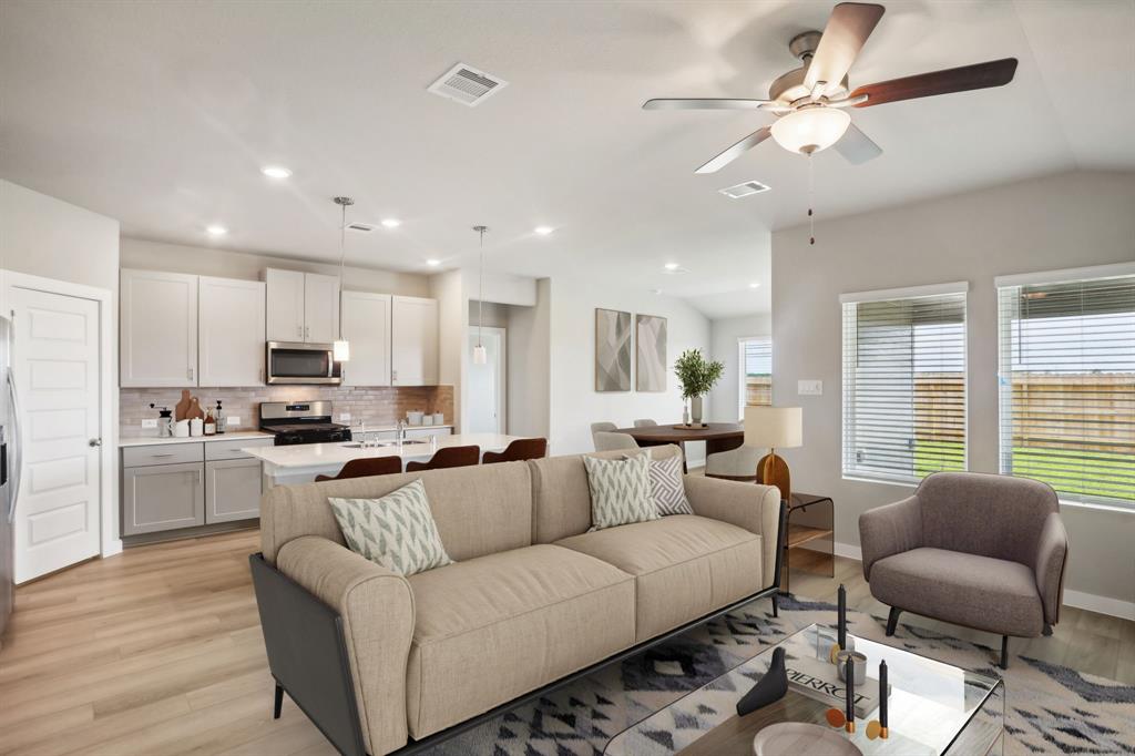 a living room with furniture kitchen and a chandelier