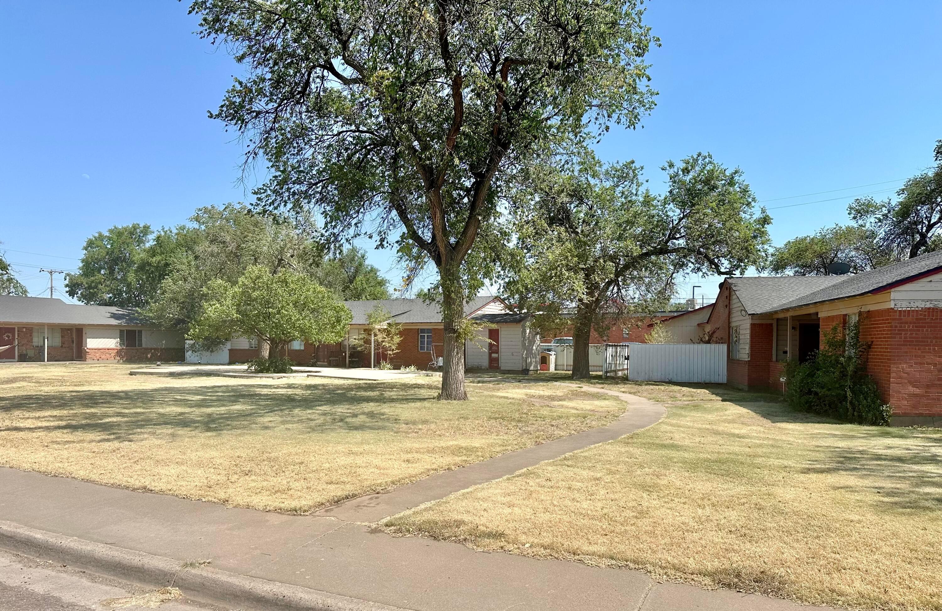 a view of a house with a yard and tree s