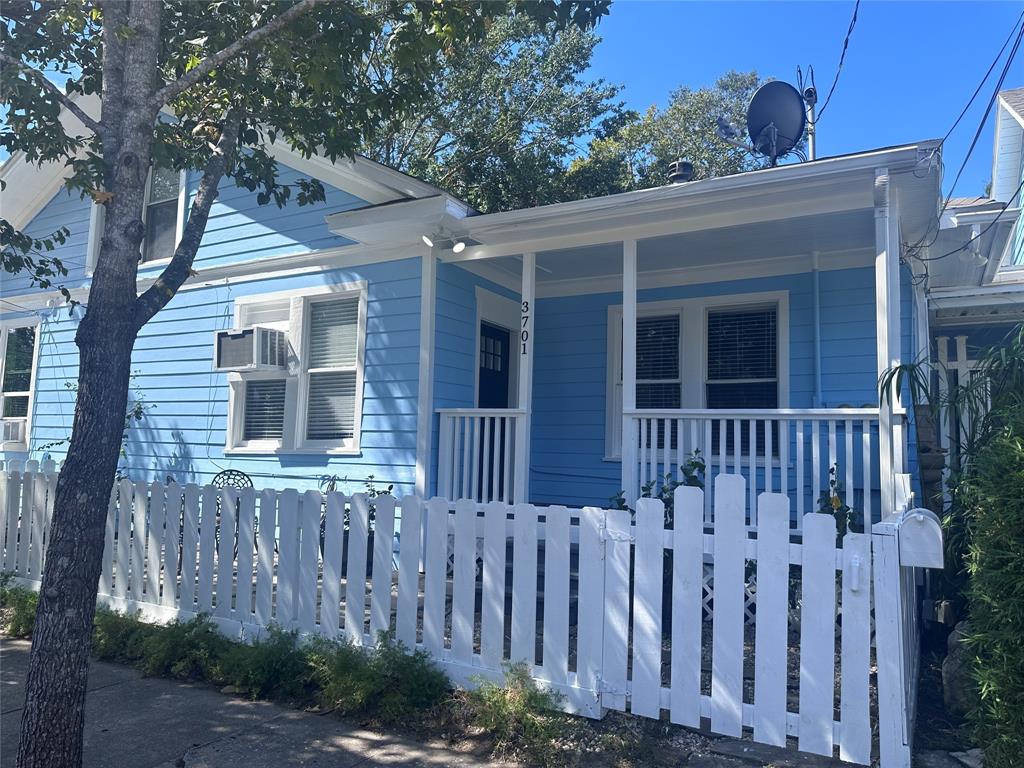 a view of a house with a small yard and wooden fence