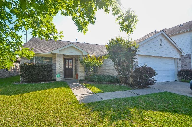 a view of a house with backyard and a tree