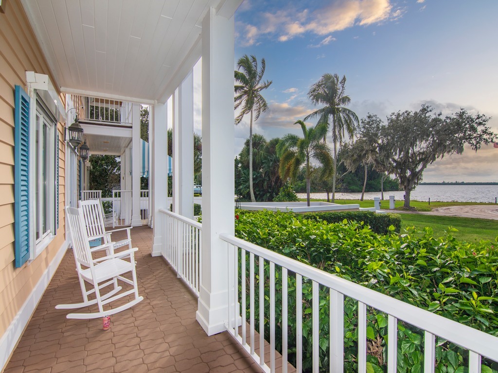 a view of a chair and tables in the yard front of the house