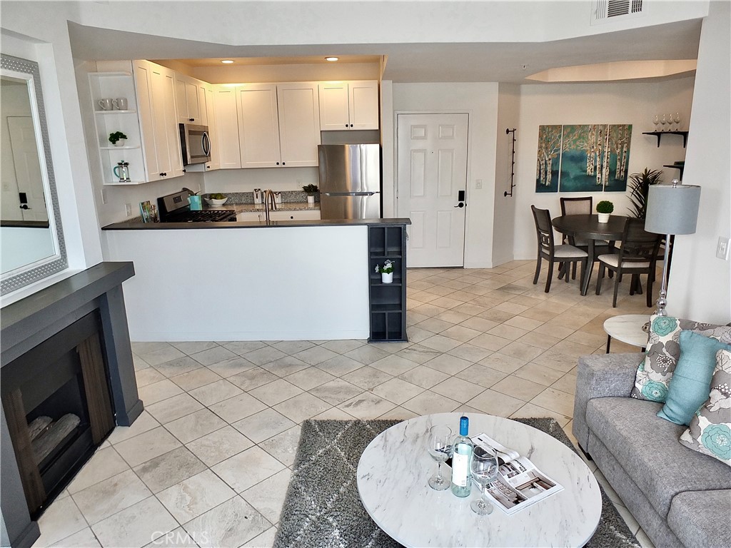 a kitchen with stainless steel appliances kitchen island granite countertop a sink and a white cabinets