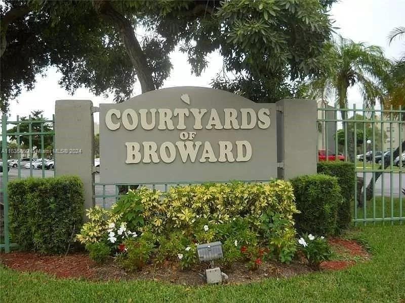 a sign broad in front of flowers