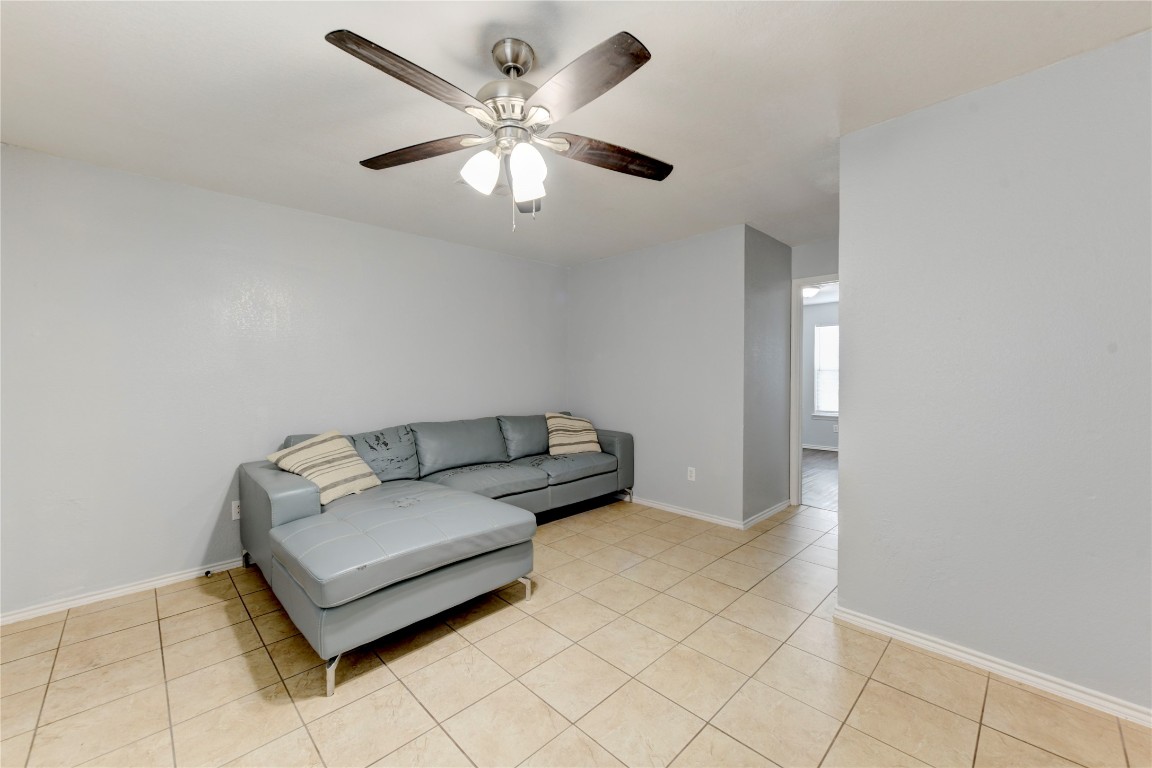 a living room with furniture and a ceiling fan